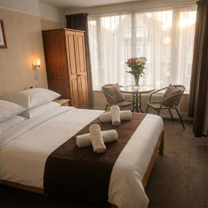 a hotel room with a bed and a table with chairs at Trevellis Bed and Breakfast in Newquay