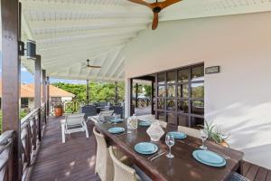 a dining room with a table and chairs on a deck at Luxury Villas with Panoramic View in Blue Bay in Blue Bay