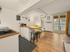 a kitchen and living room with a counter and stools at Sous Les Toits in Valence +7 photos