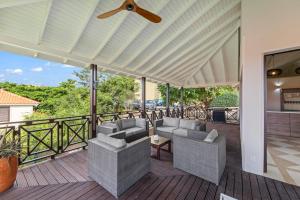 a patio with chairs and a ceiling fan at Luxury Villas with Panoramic View in Blue Bay in Blue Bay +68 photos