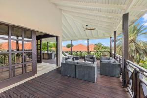 an outdoor deck with couches and chairs at Luxury Villas with Panoramic View in Blue Bay in Blue Bay