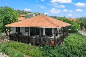 a house with an orange roof with a deck at Luxury Villas with Panoramic View in Blue Bay in Blue Bay
