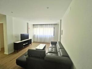a living room with a couch and a television at JLKM Mindelo Central Residence in Mindelo +6 photos
