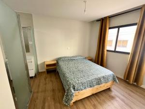 a bedroom with a bed and a large window at JLKM Mindelo Central Residence in Mindelo