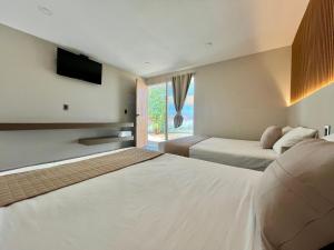 a hotel room with two beds and a television at Hotel Mare in Santa Maria Huatulco