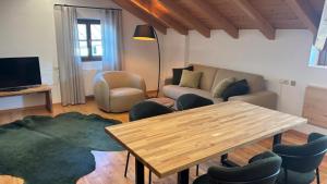 a living room with a table and a couch and chairs at Villa Santer in Dobbiaco