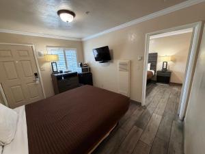 a bedroom with a bed and a television and a door at SurfSide Stay in Morro Bay