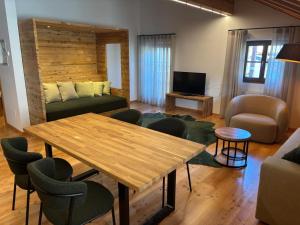a living room with a wooden table and chairs at Villa Santer in Dobbiaco +14 photos