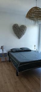 a bedroom with a bed and a heart on the wall at Appartement face golf et océan in Saint-Jean-de-Monts