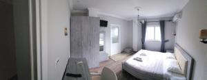 a bedroom with a bed and a table in it at JULI Veal in Tepelenë