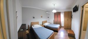 a hotel room with two beds and a desk at JULI Veal in Tepelenë