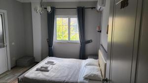 a small bedroom with a bed and a window at JULI Veal in Tepelenë