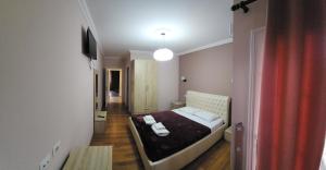 a hotel room with a bed and a television at JULI Veal in Tepelenë