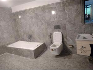a bathroom with a tub and a toilet and a sink at Hotel shree ji in Lucknow
