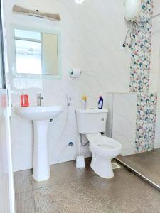 a bathroom with a white toilet and a sink at Laxury3BR Mins to Nyali Beach fast WiFi Netflix AC and Free Parking Near wild waters in Mombasa
