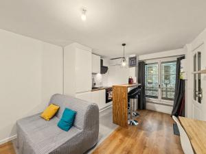 a living room with a couch and a kitchen at Le Refuge in Valence