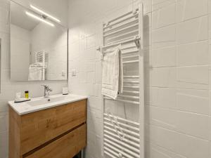 a white bathroom with a sink and a shower at Le Refuge in Valence