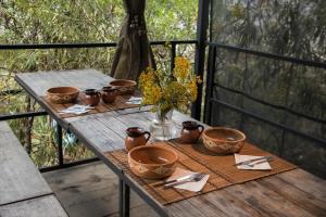 a wooden table with bowls and flowers on it at Cabañas Yei Calli in Ciudad Mendoza
