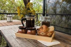 a wooden table with a tray of bread and jars of preserves at Cabañas Yei Calli in Ciudad Mendoza +30 photos