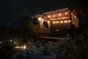 a pergola with lights in a garden at night at Cabañas Yei Calli in Ciudad Mendoza