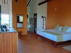 a bedroom with a bed and a bathroom with a sink at HotelQuintaMaria in Barichara
