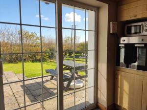 a kitchen with a view of a picnic table through a window at Woodmount Cottage in Ennistymon