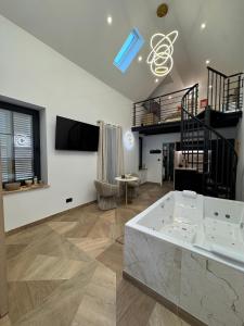 a large room with a bath tub and a staircase at Spa Signature in Dijon +11 photos