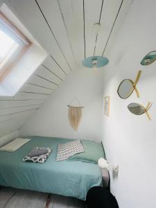 a bedroom with a green bed in a attic at White and Sea Lodge in Locquirec +44 photos