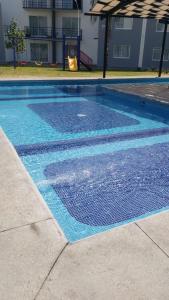 a swimming pool with blue tiles on the ground at La Casa de Coco in Oacalco +31 photos