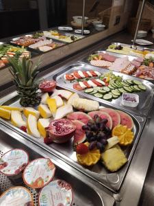 a buffet with many different types of food on trays at Hotel LEANO in Lübeck