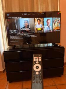 a remote control in front of a flat screen tv at MiraLago Pool Paradise in San Antonio