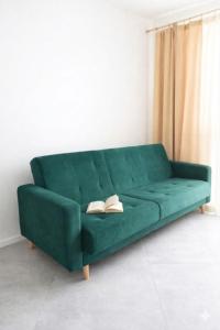 a green couch with two books on it in a room at Apartament na Bora in Tarnów