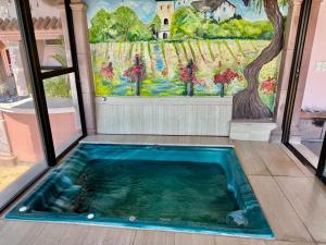a hot tub in a room with a painting on the wall at MiraLago Pool Paradise in San Antonio +5 photos