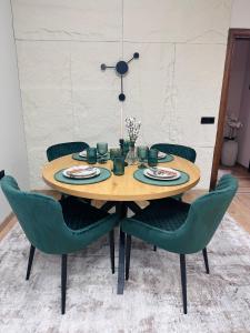 a wooden table with green chairs in a room at martIN Apartment 2 in Bansko +22 photos