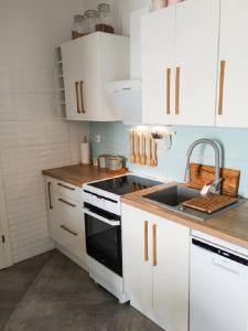 a kitchen with white cabinets and a sink at Apartament na Bora in Tarnów