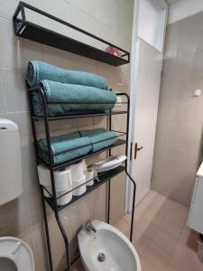 a bathroom with a rack with towels and a toilet at "Le Betulle 10" cinque minuti dal mare, Self check in in Bibione +40 photos