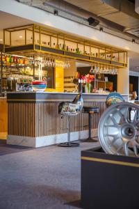 a restaurant with a bar with chairs in front of it at Brit Hotel Le Cottage Le Mans Sud in Arnage