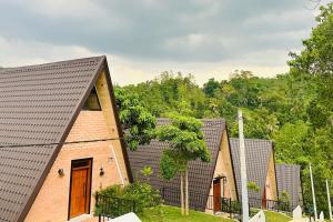 a group of small houses with trees in the background at Bherunda Mount Resort in Kegalle