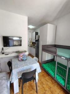 a small room with a table and bunk beds at "Le Betulle 10" cinque minuti dal mare, Self check in in Bibione