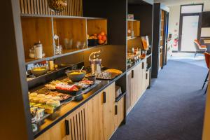 a kitchen with a buffet of food on a counter at Brit Hotel Le Cottage Le Mans Sud in Arnage +17 photos