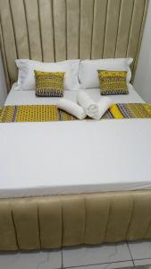 a bed with white sheets and pillows on it at Jojos Serenity Stay in Bamburi