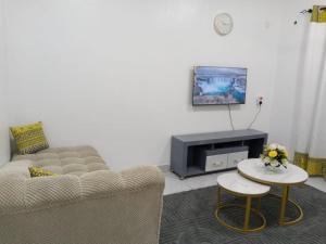 a living room with a couch and a tv at Jojos Serenity Stay in Bamburi