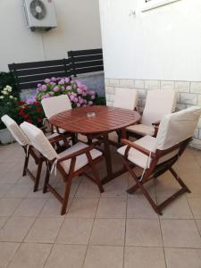 a wooden table and chairs and a table and flowers at Apartment Pavin in Poljana +6 photos