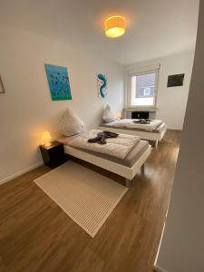 two beds in a room with wooden floors at Kaiserviertel Gastromeile, City, Messe & Stadionnah in Dortmund
