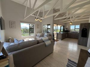 a living room with a couch and a table at Elephant View Homestead - Hydrangea Cottage in Plettenberg Bay