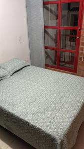 a bed in a room with a red window at Casa Roma - La tranquilidad del campo en la Ciudad - RNT 1 0 8 1 3 7- in Salento