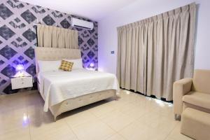 a bedroom with a bed and a chair at MB Apartment - A in San Felipe de Puerto Plata