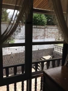 an open window with a view of a brick wall at Mansion Samzara Hosteleria in Sangolquí