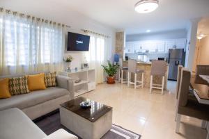 a living room with a couch and a table and a kitchen at MB Apartment - A in San Felipe de Puerto Plata
