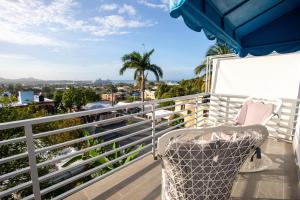a chair on a balcony with a view of the city at MB Apartment - A in San Felipe de Puerto Plata
